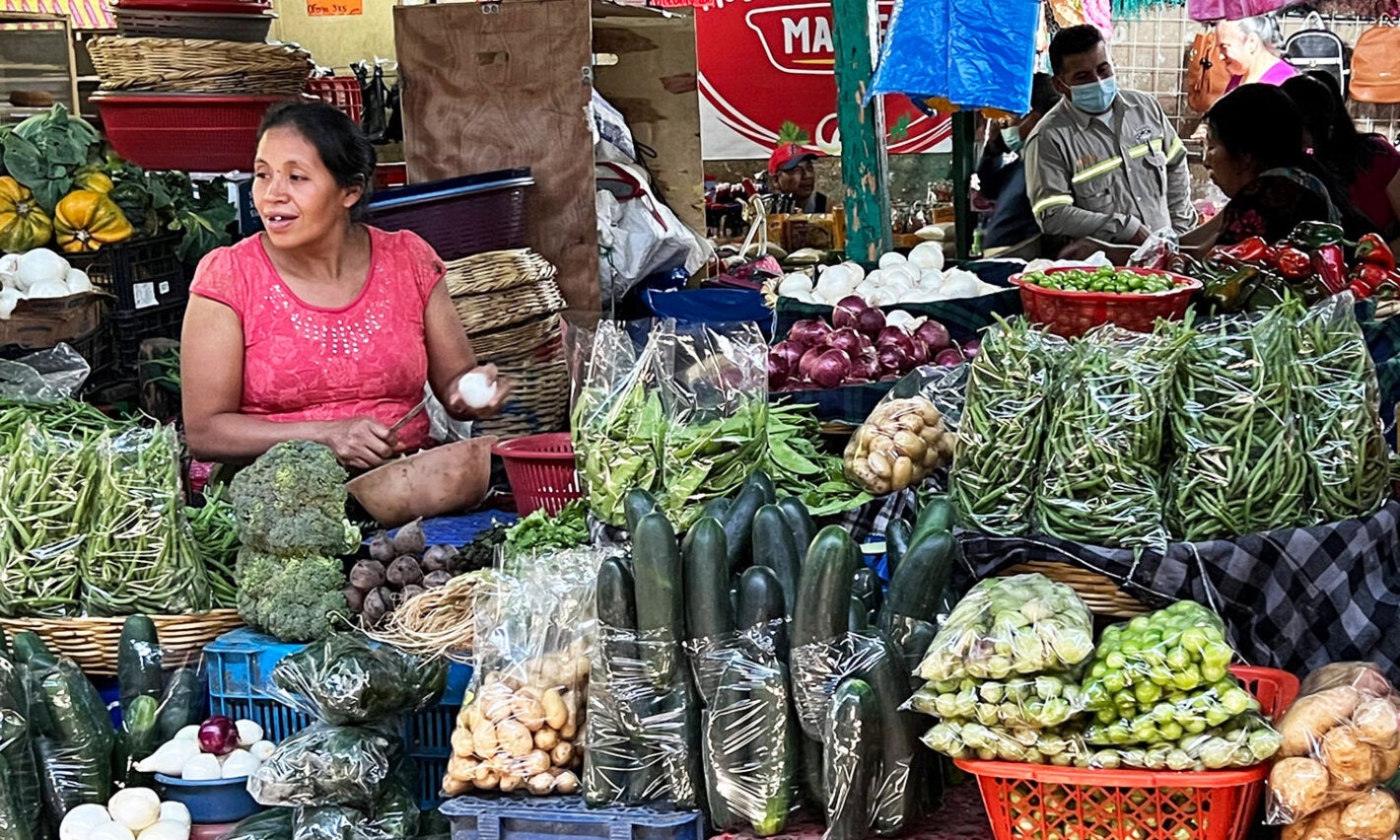 mujer vendiendo verduras en mercado tradicional en Guatemala
