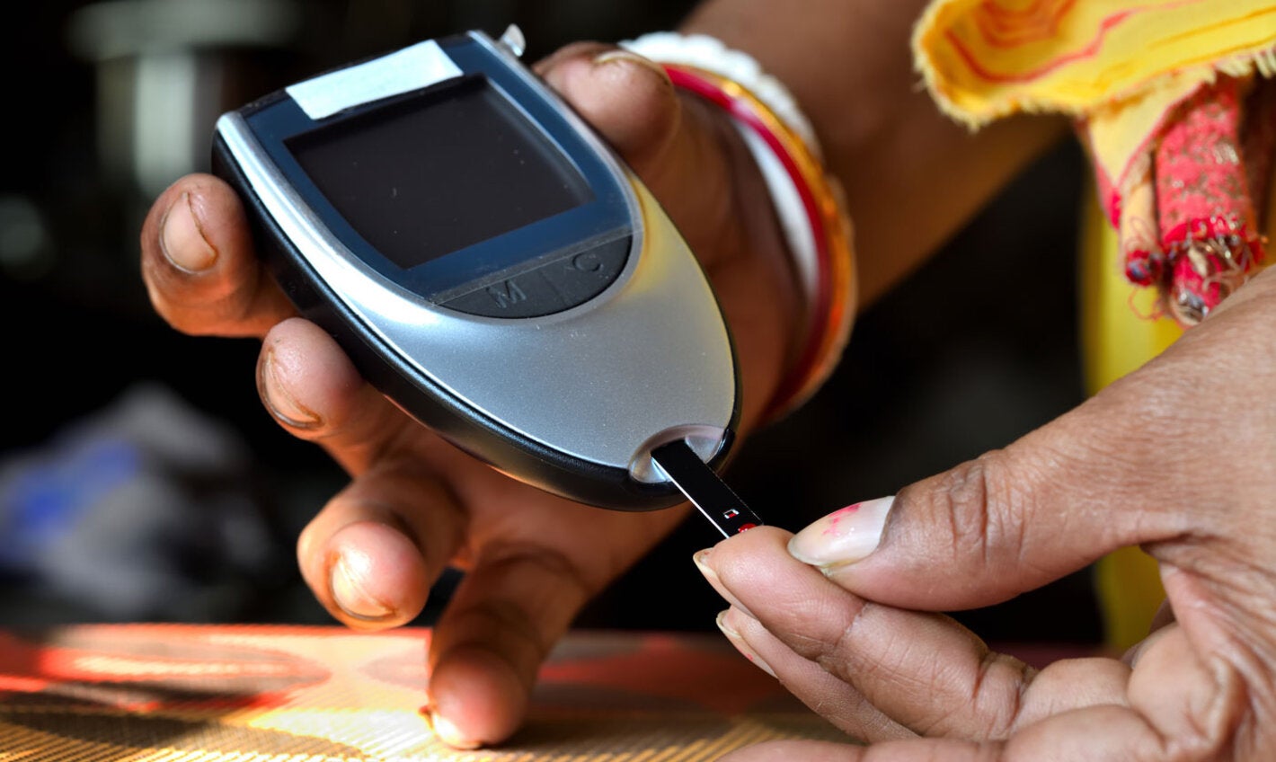 Woman testing blood sugar level