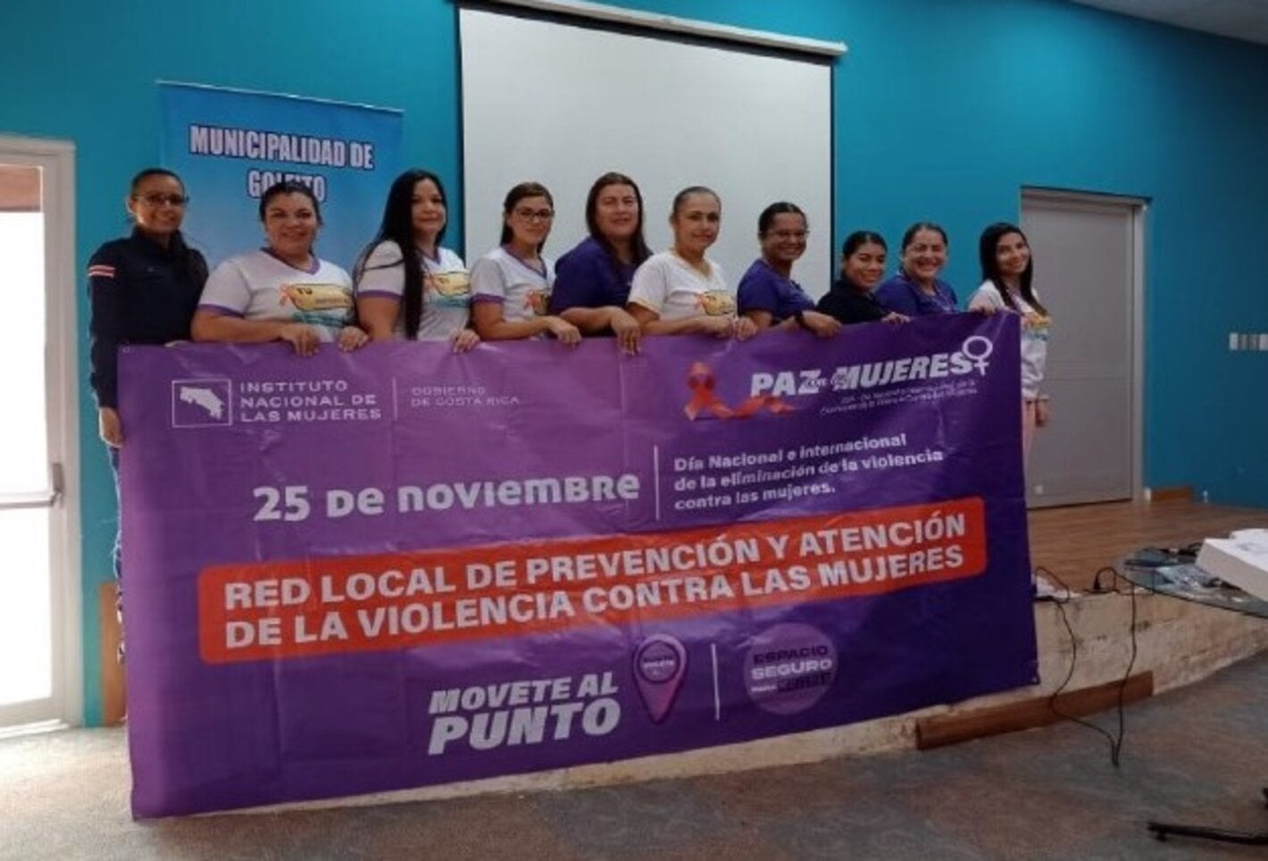 Grupo de mujeres participantes sosteniendo una pancarta