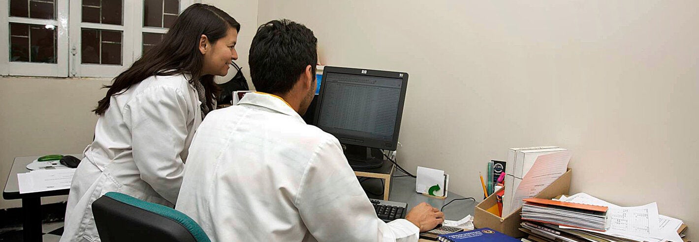 Dos trabajadores de salud ven un monitor