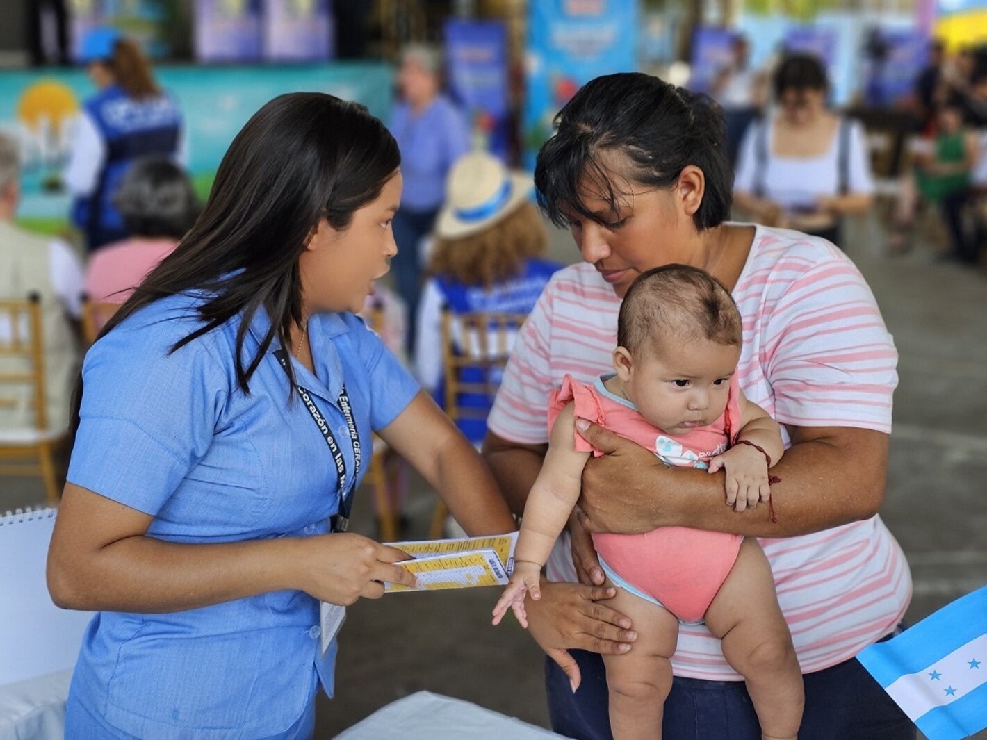 Enfermera junto a madre y niño vacunado