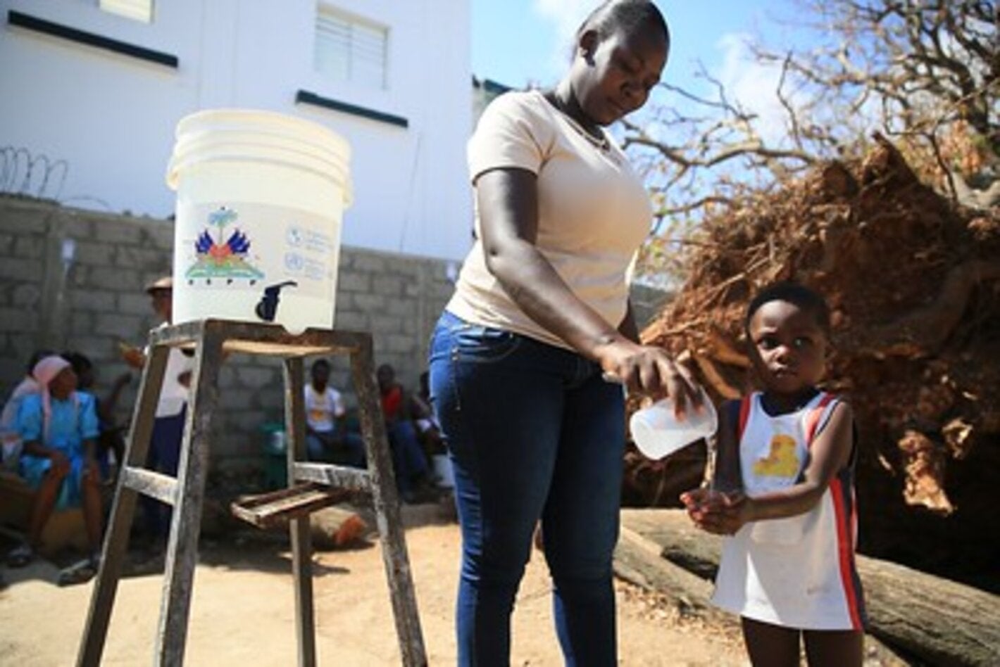Girl washing hands of a child to prevent him from cholera