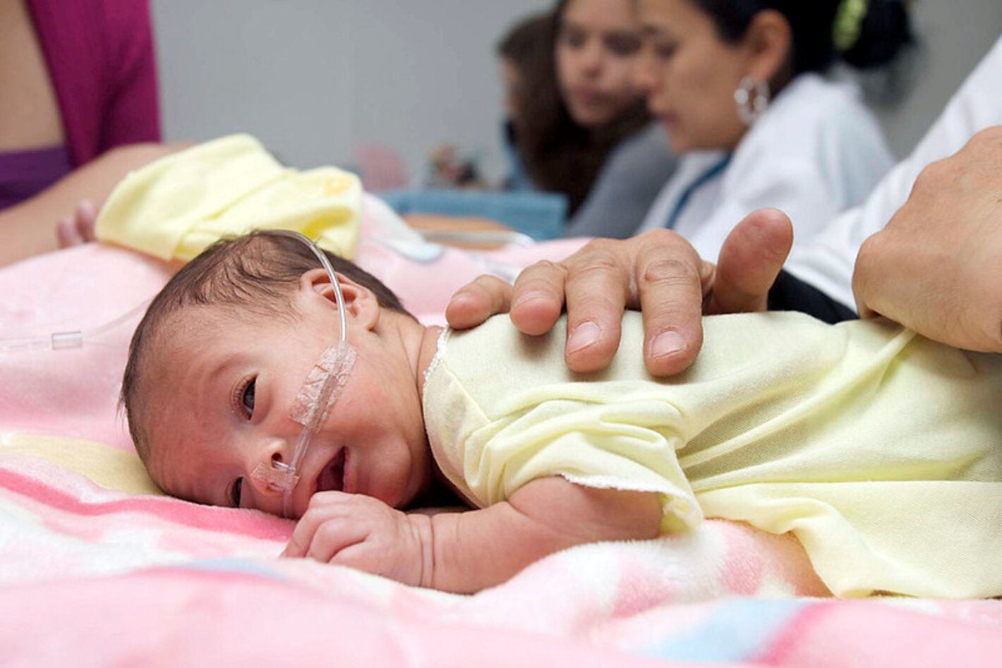 bebe prematuro, acostado boca abajo siendo revisado por personal de salud