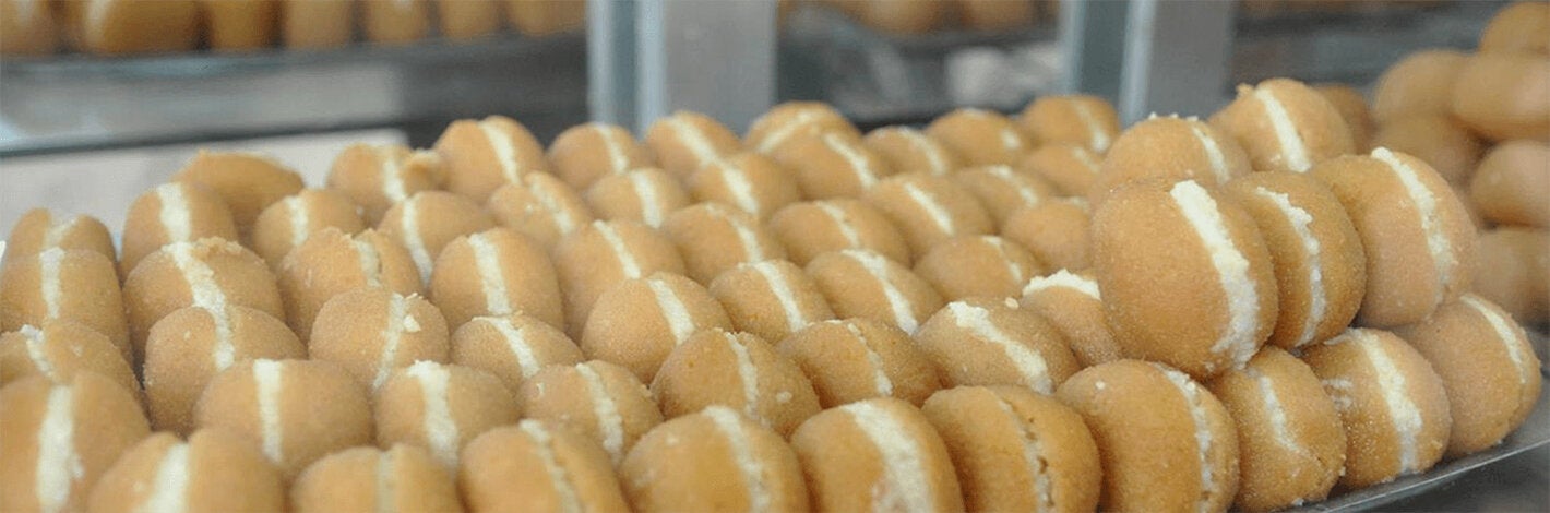 baking sheet full of cream-filled sugar-coated fried pastries