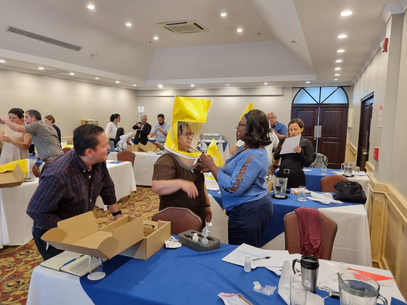 Large event room. Participants are learning how to use personal protection equipment on a respiratory protection training