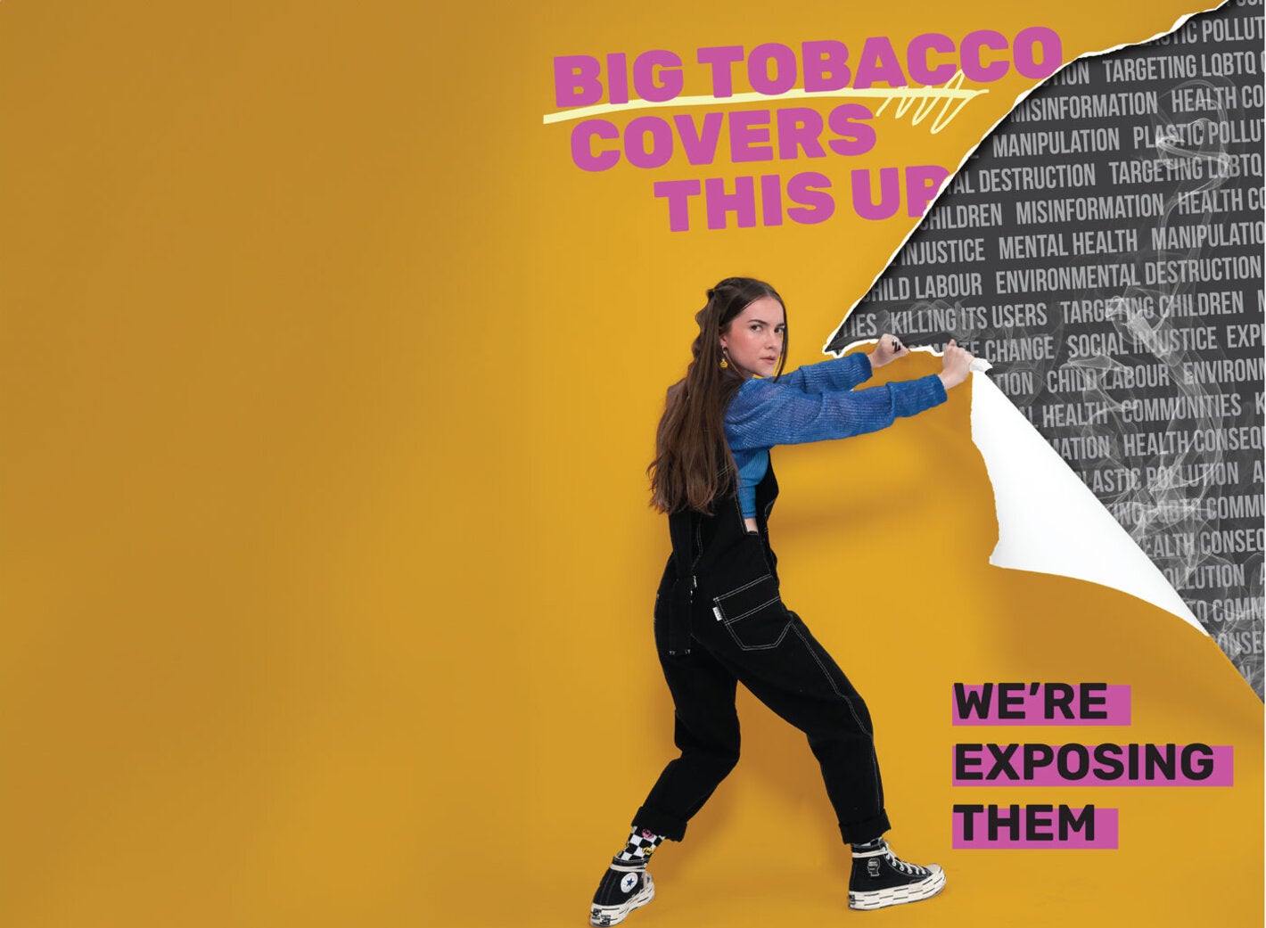 Una adolescnete pela una pared donde están escritos los peligros para la salud del tabaco