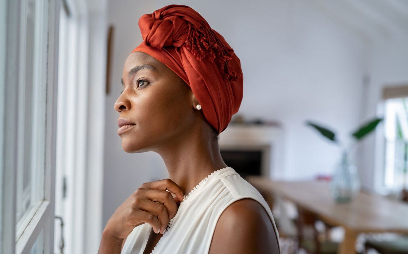 Woman with head turban looking out the window