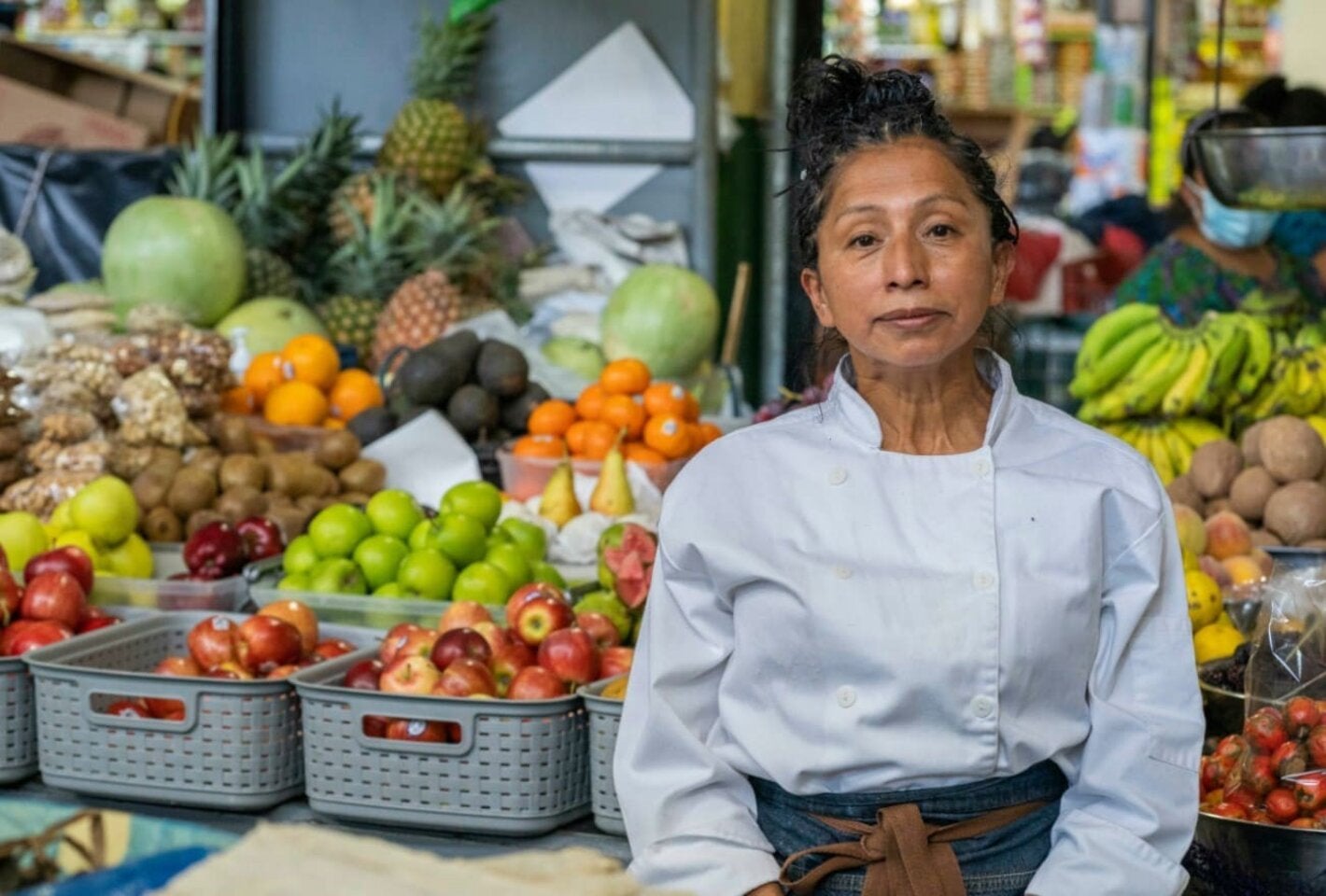 Mujer vende vegetales y frutas en mercado