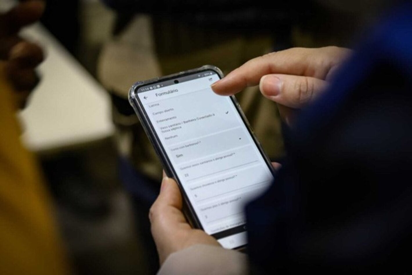 Person holding phone with EWARS, cell phone app