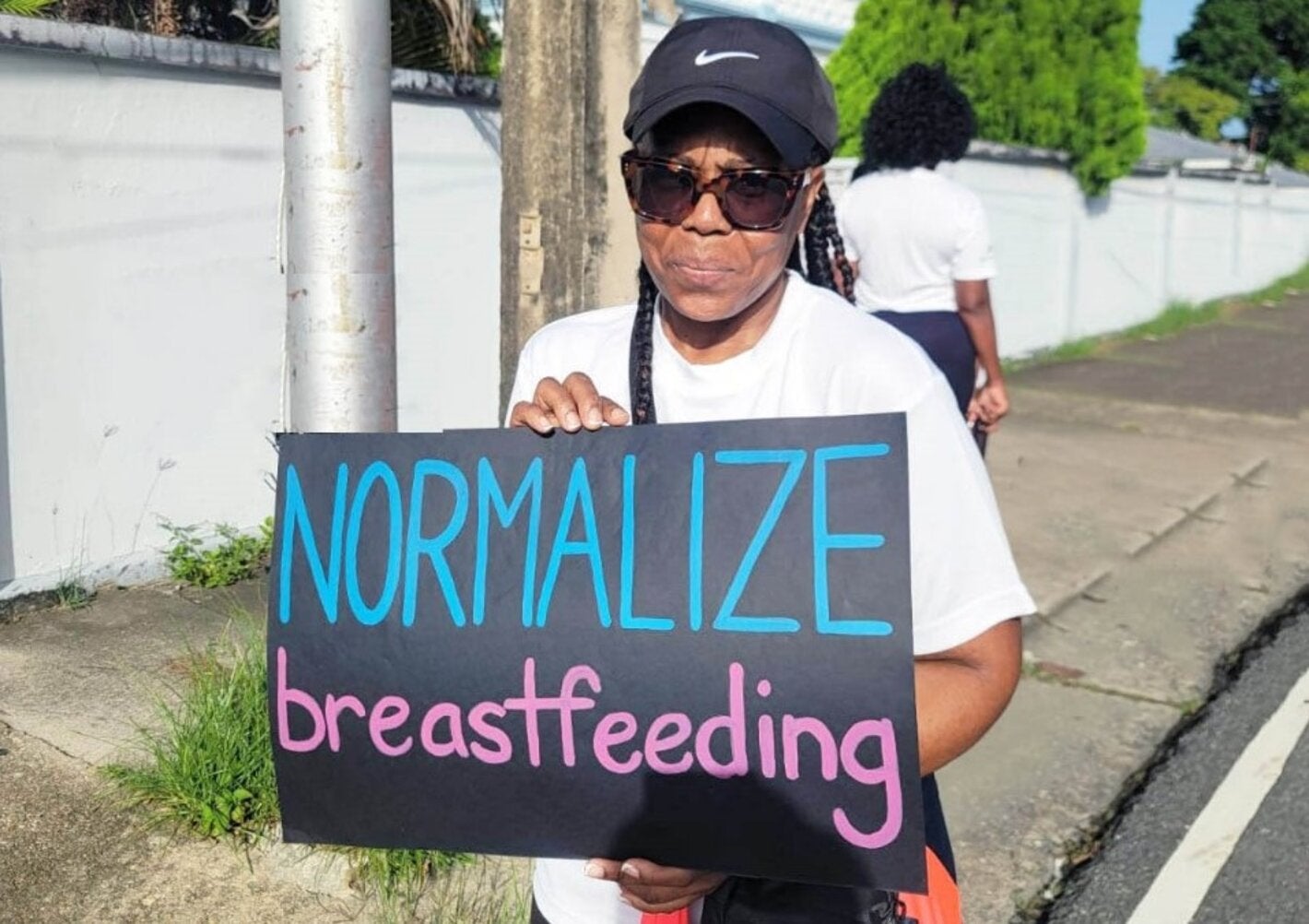 Lady holds sign - Normalize Breastfeeding