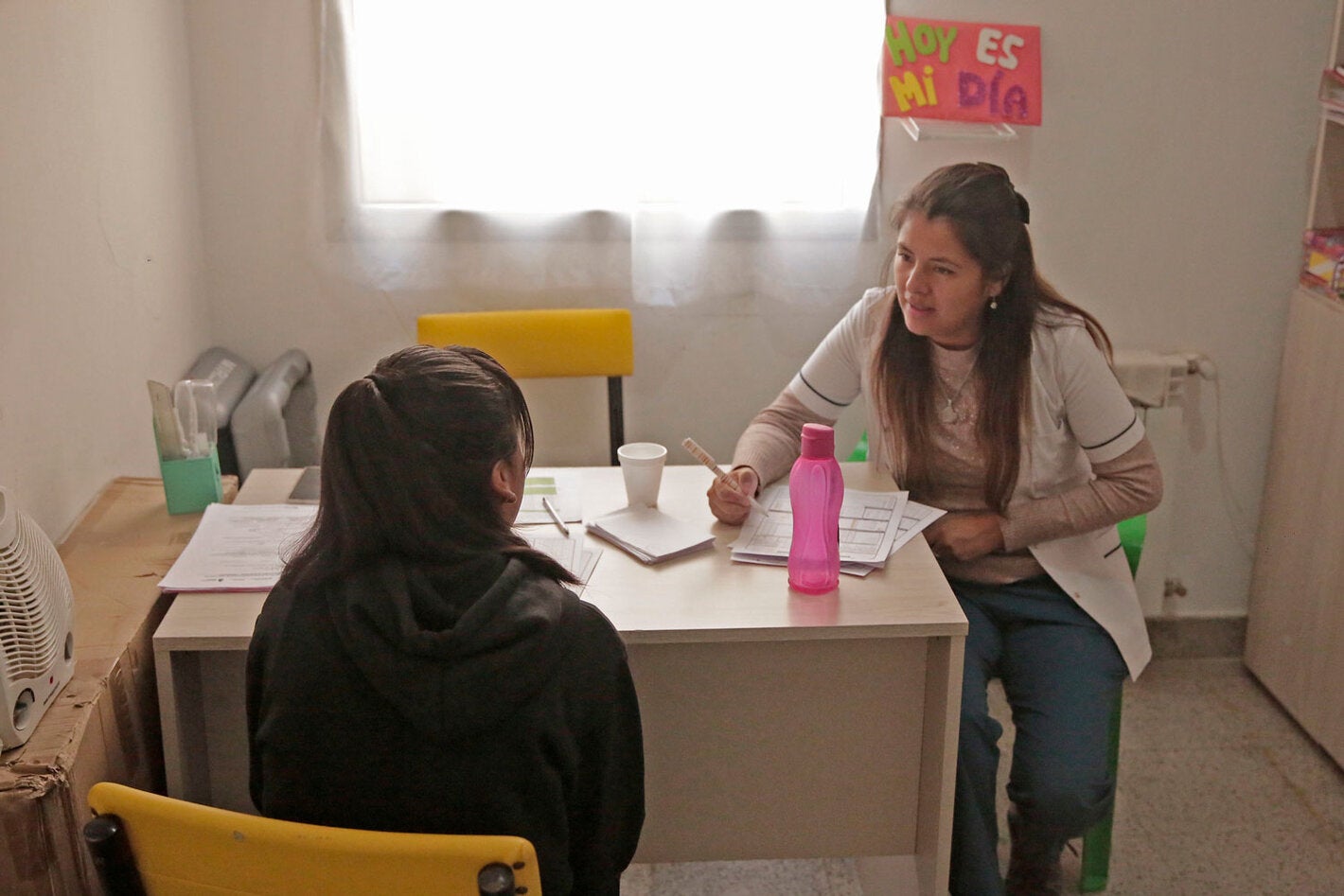 Woman at a clinic talking to female doctor