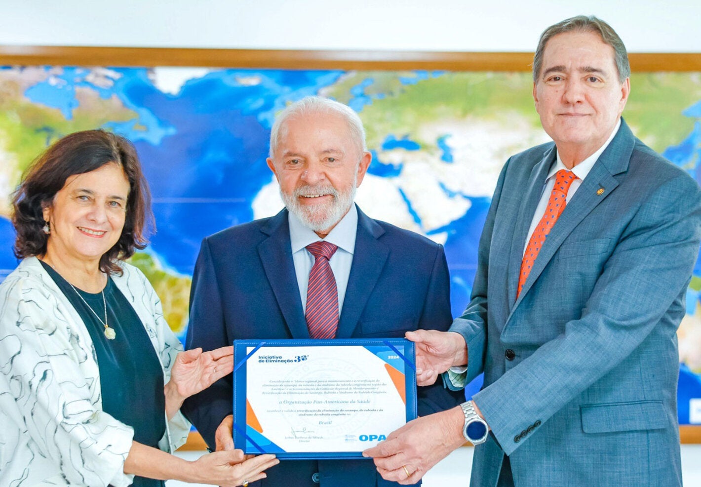 El Dr. Jarbas Barbosa, el Presidente de Brasil, Luiz Inácio Lula da Silva, y la Ministra de Salud, Nísia Trindade, sujetan la certificación de Brasil que lo declara libre de sarampión.