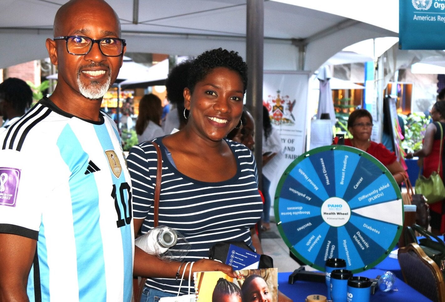 A couple at the PAHO/WHO TTO booth at the UNDP Caravan