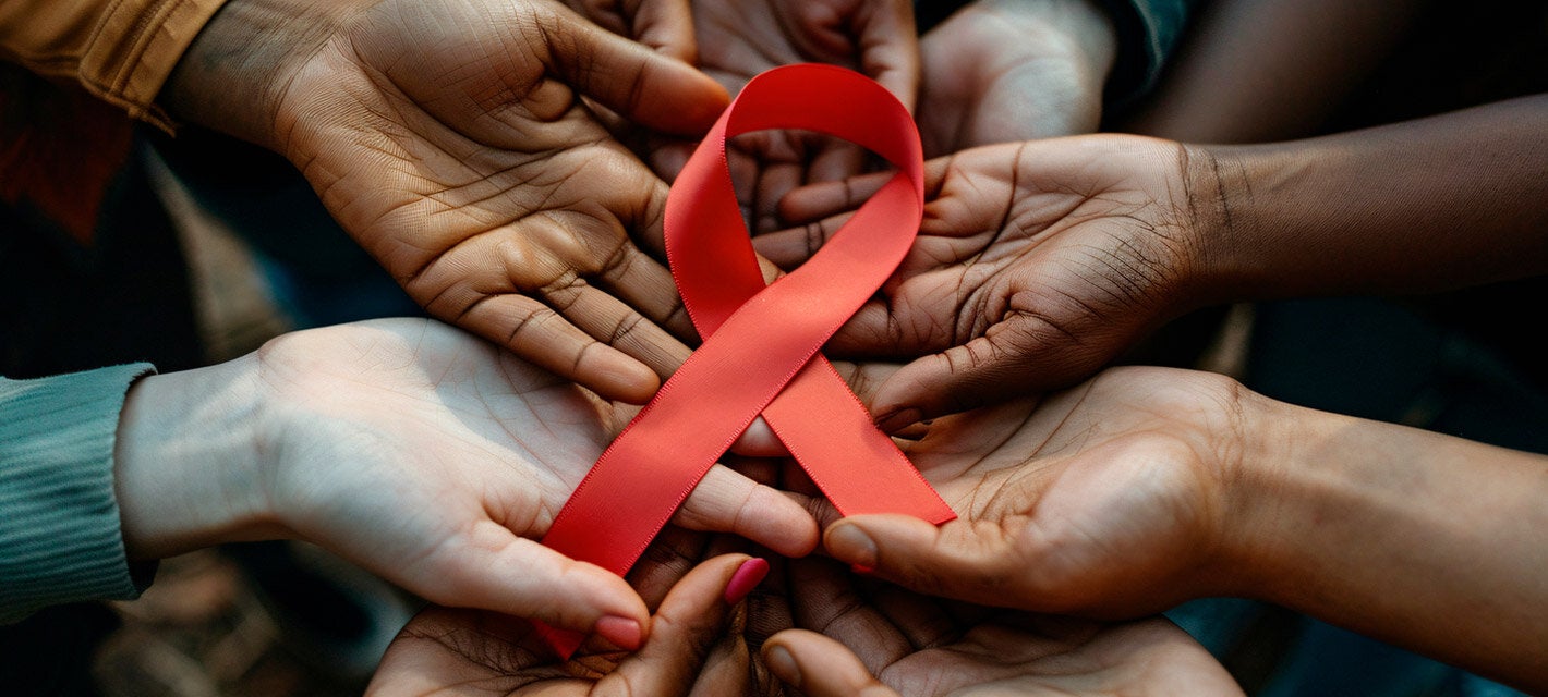 manos de personas de distintas nacionalidades sosteniendo el lazo representativo al Sida