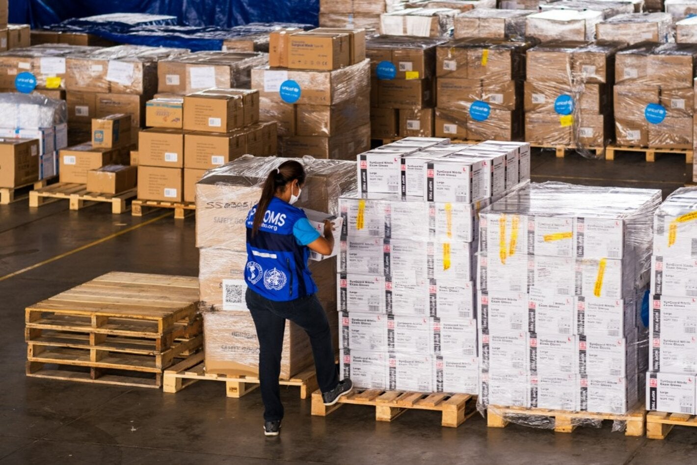 woman checks boxes in a warehouse