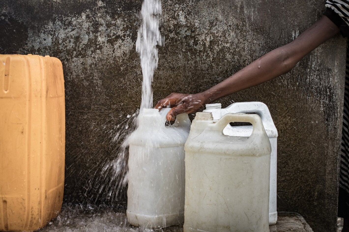 Mujer recogiendo agua en Haití