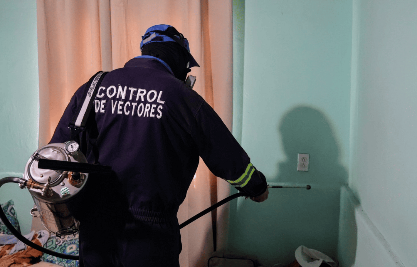 Inspector de salud durante la práctica de rociado dentro de una vivienda