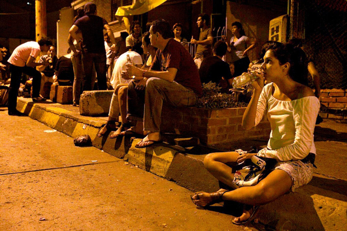 Grupo de jóvenes consumen bebidas alcohólicas en la vía pública