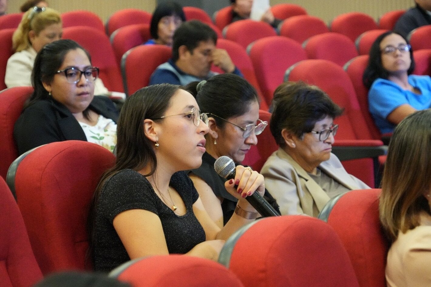 participante del taller sujeta el micrófono para tomar la palabra