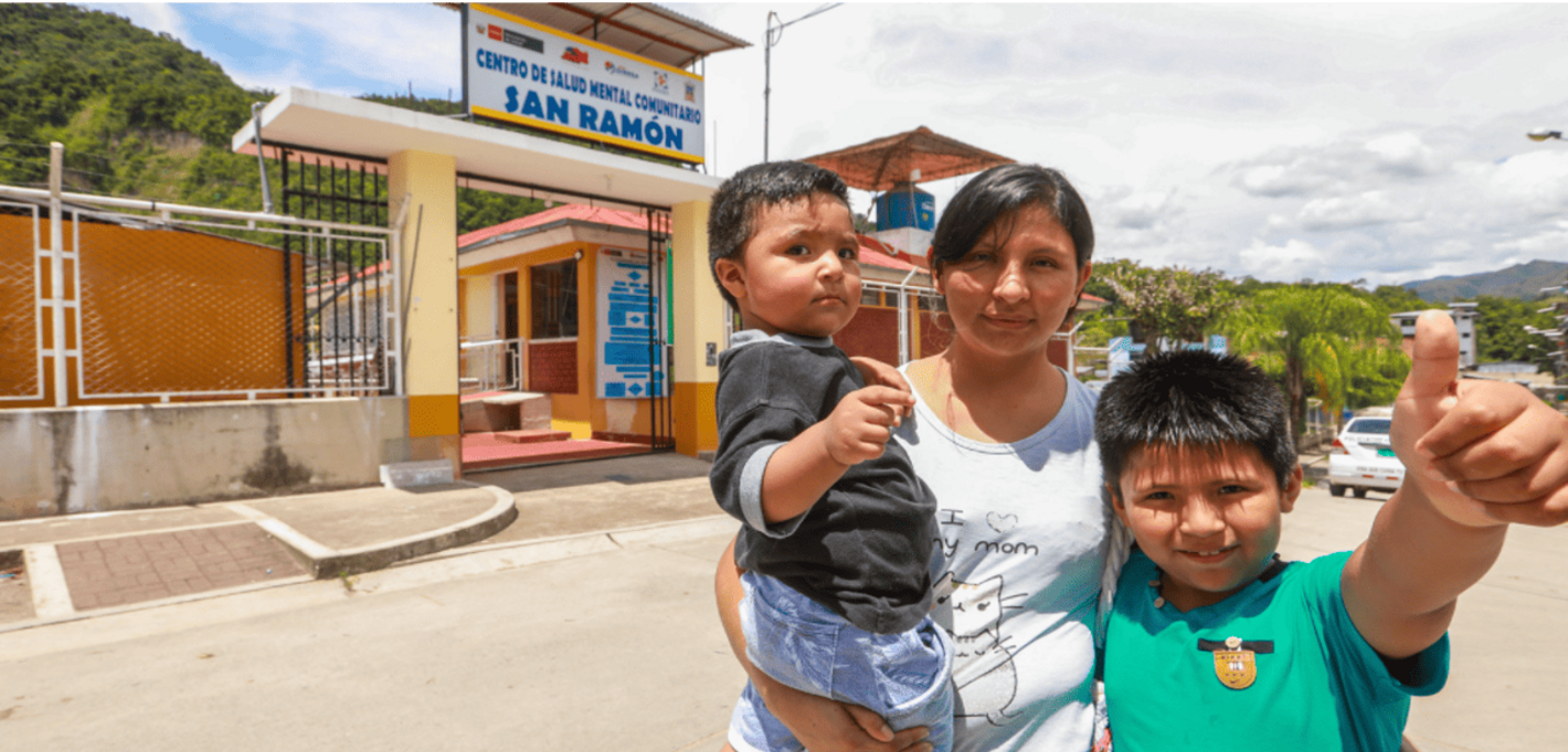 madre junto a sus niños en las afueras de un centro de salud mental comunitario