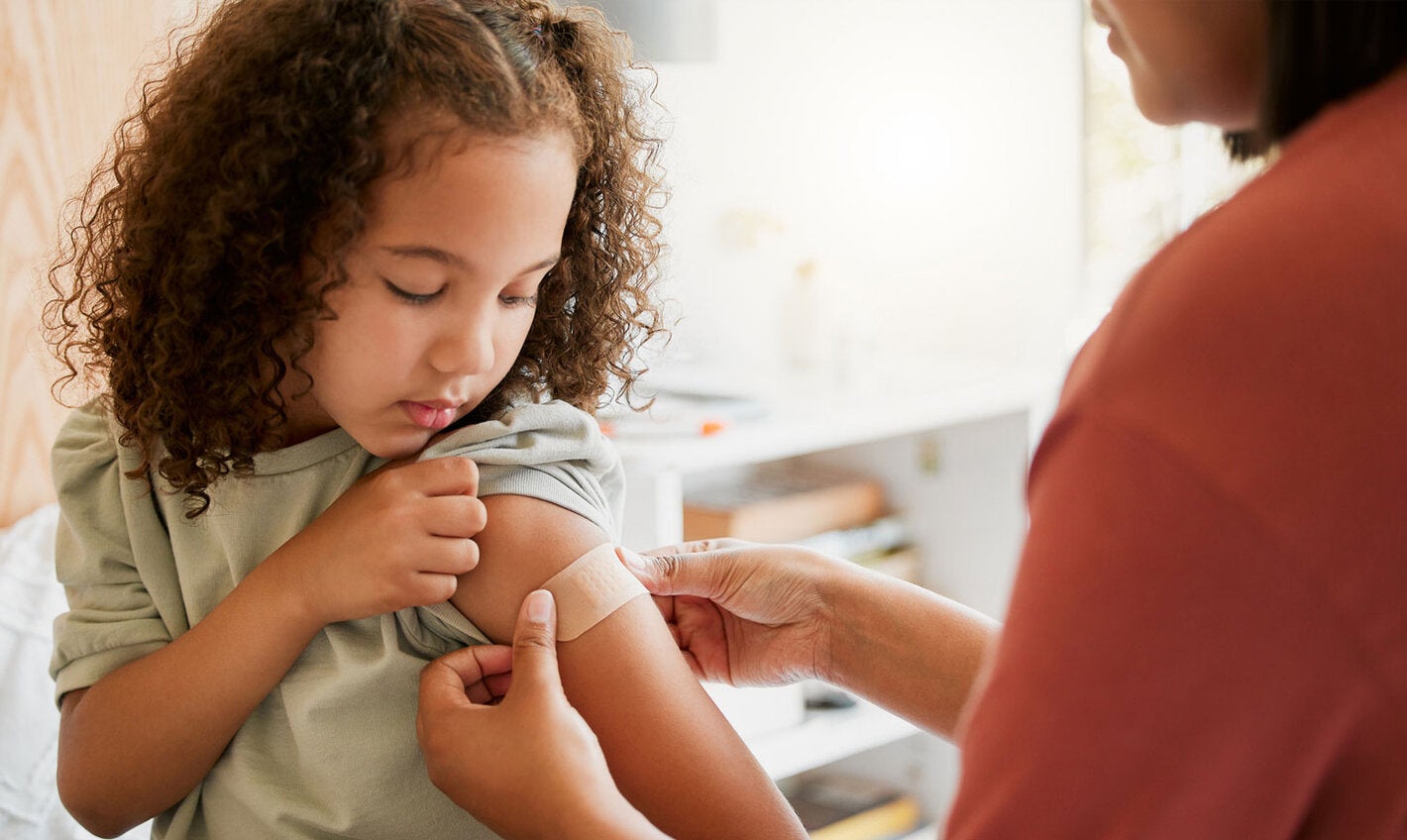 Girl gets a band aid after being vaccinated