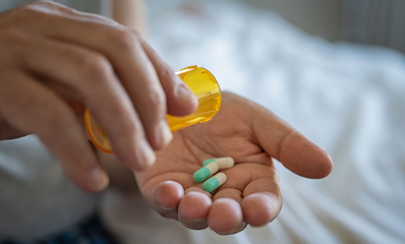 Woman holds antibiotics on her hand