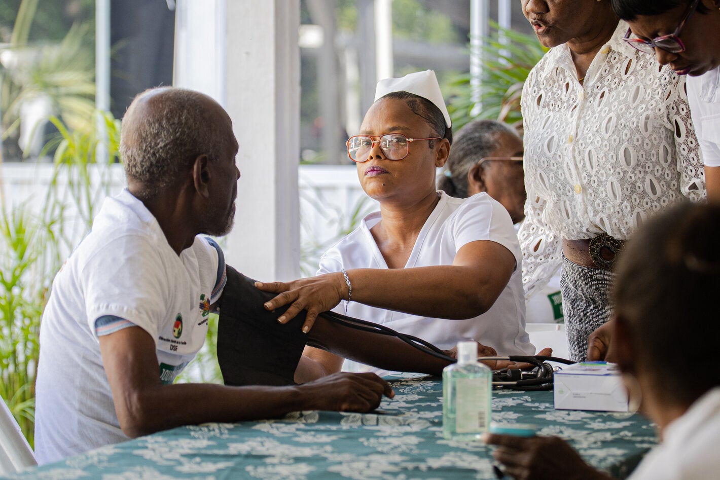woman taking pressure of older persons