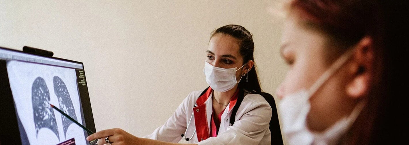 Médica mostrando resultado de exame de pulmão para paciente