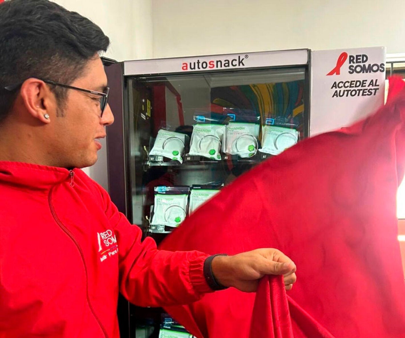 Personaje destapando maquina dispensadora de pruebas de tamizaje