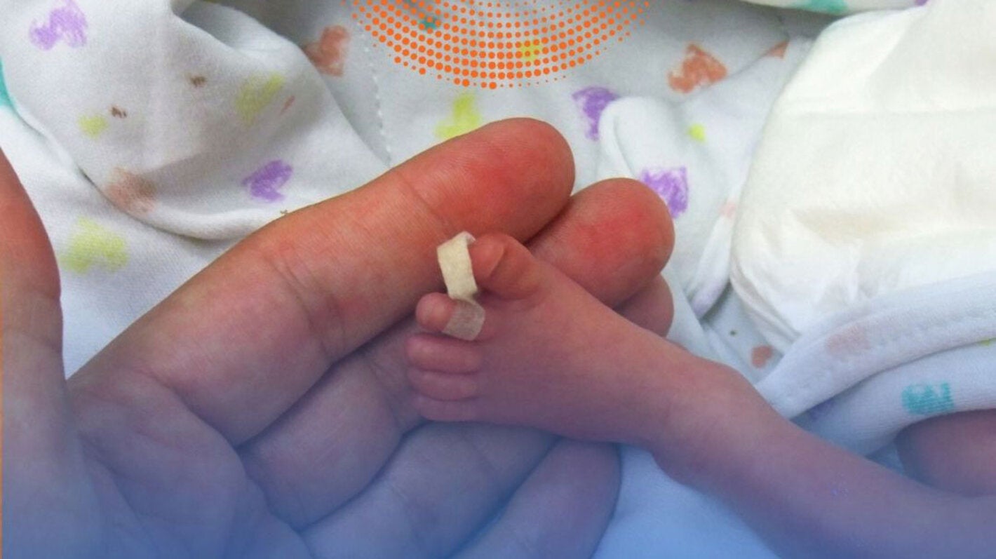 Foot of premature baby on a mother's hand