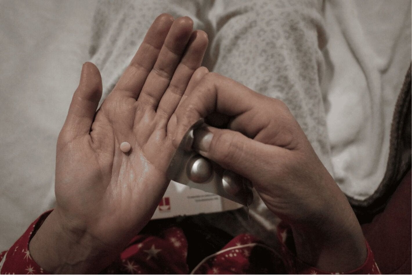 manos muestran un blíster de medicamentos