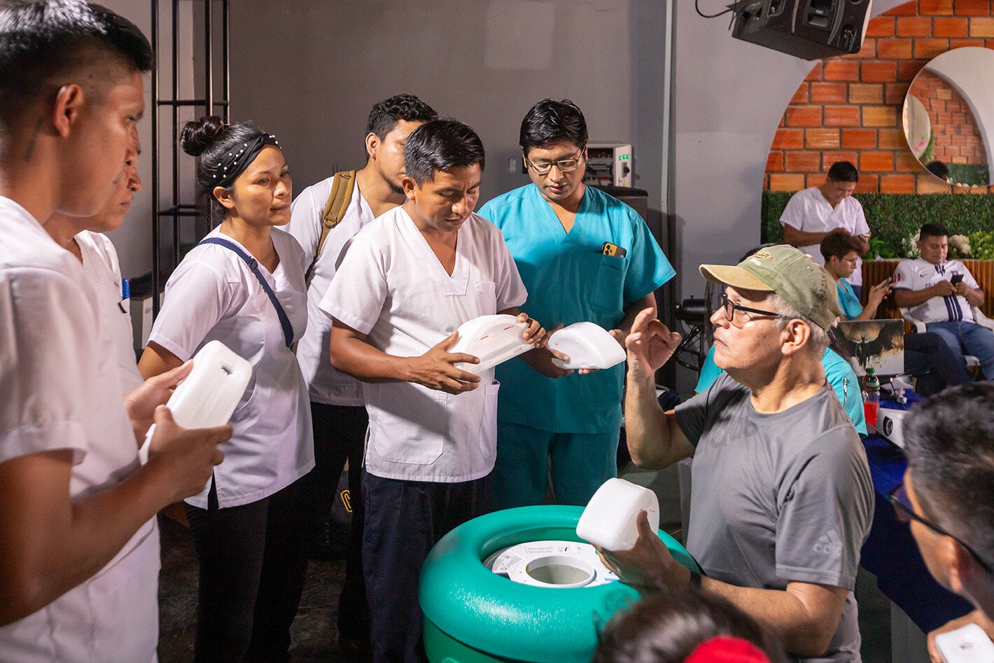 Personal de salud practica cómo colocar los paquetes congelantes en la caja fría pasiva de larga duración.