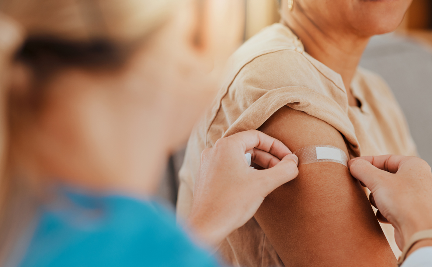 Patient after being vacciated gets a bandaid