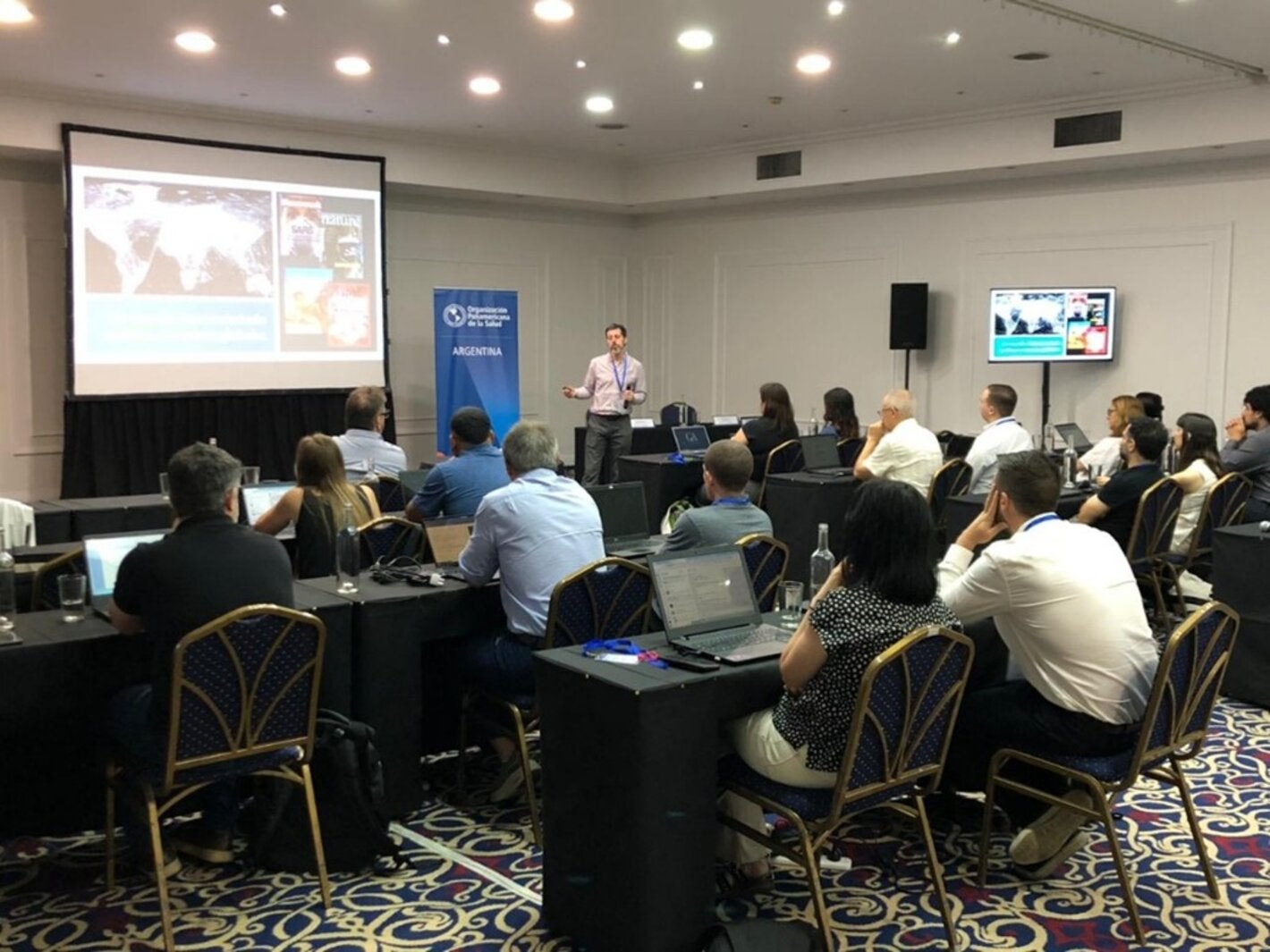 participantes de taller sentados en un salon de eventos.