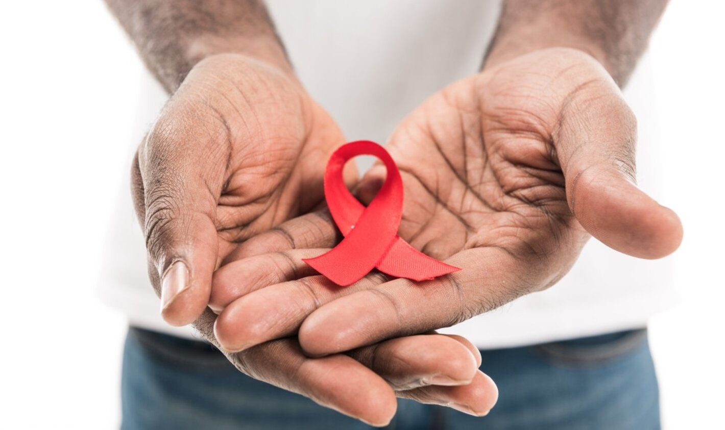 Un hombre sostiene la cinta asociada con el VIH