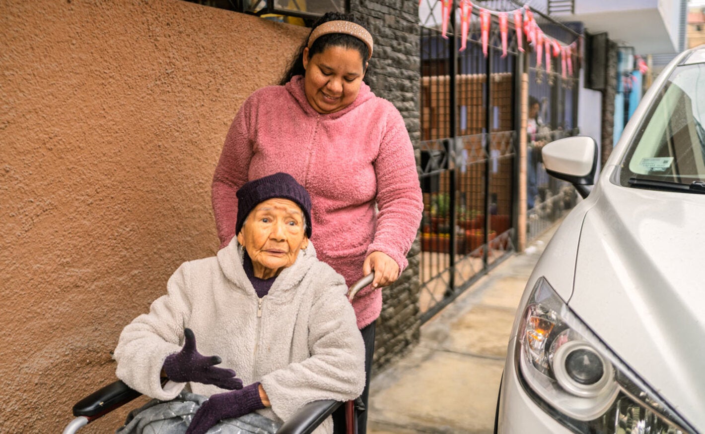 elderly woman in wheelchair being pushed