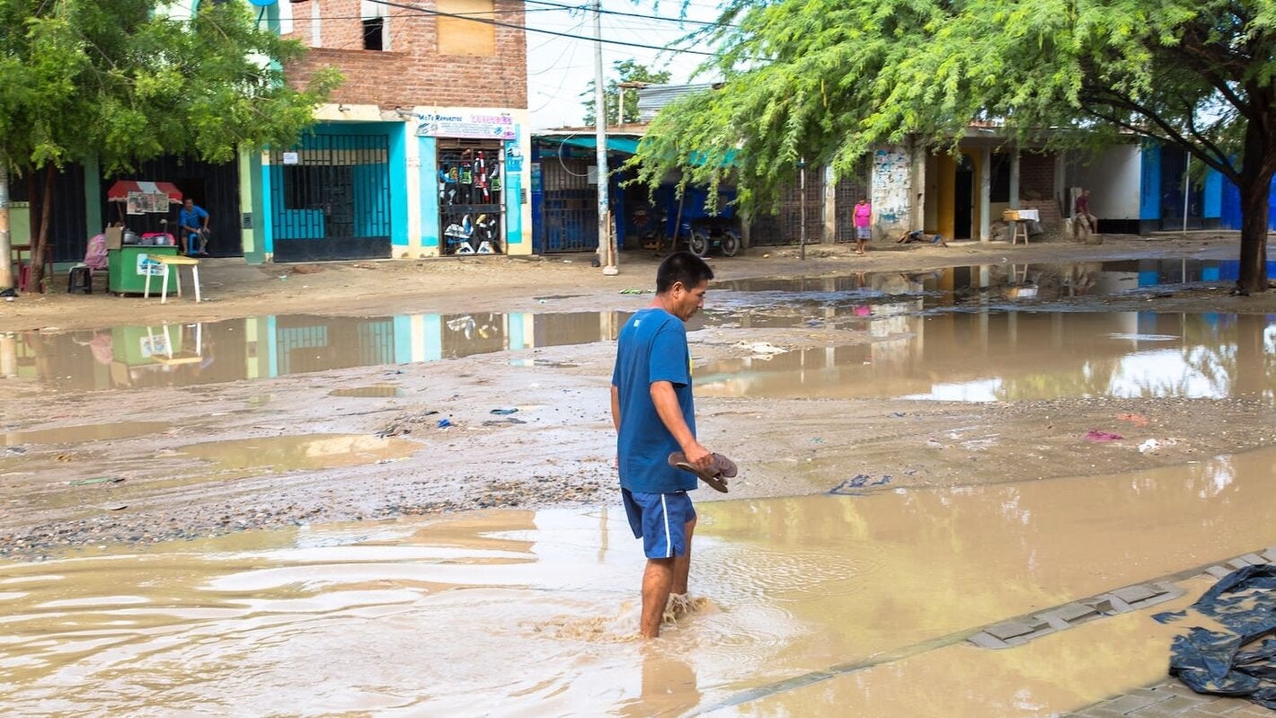 hombre en medio de un charco de agua provocada por las lluvias