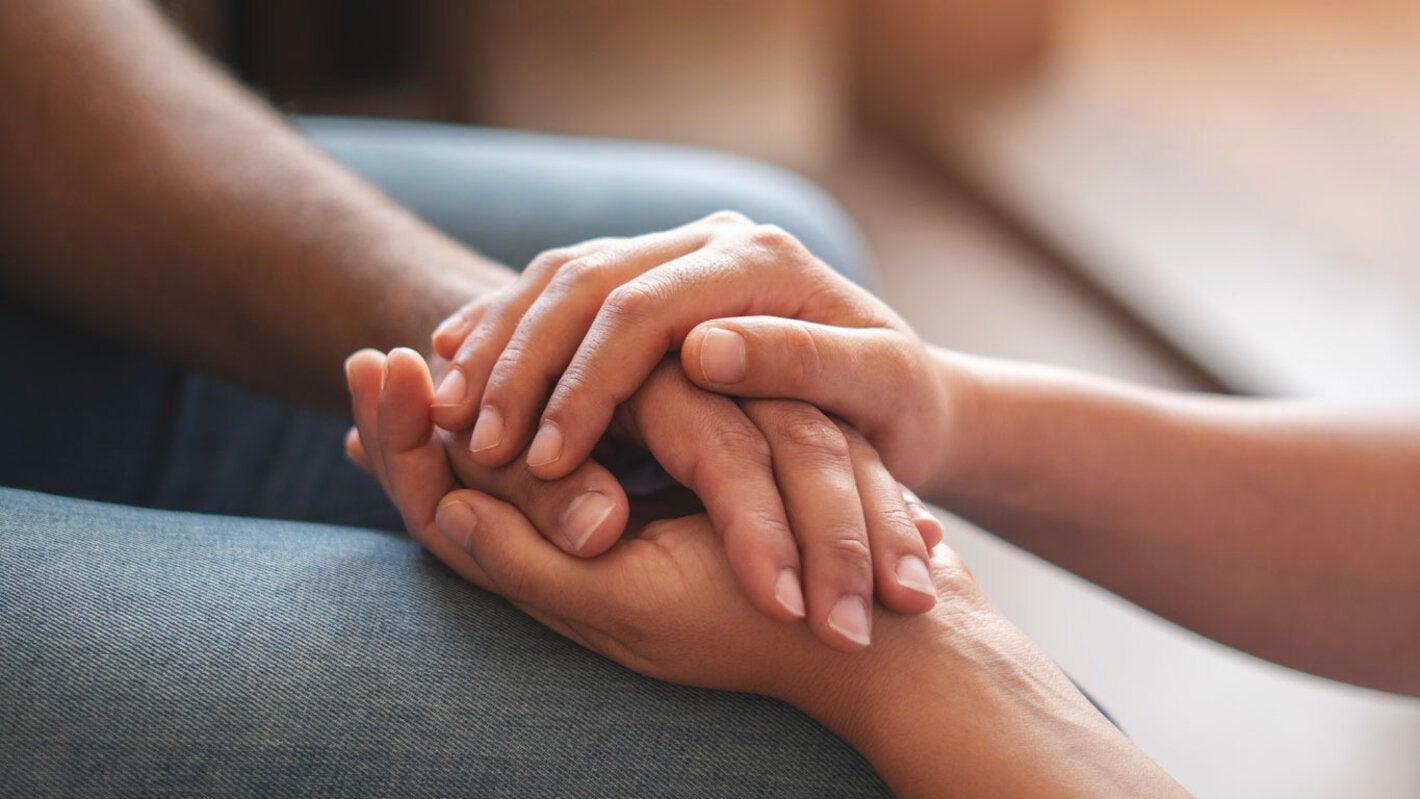 Dos personas se dan la mano en un gesto de apoyo