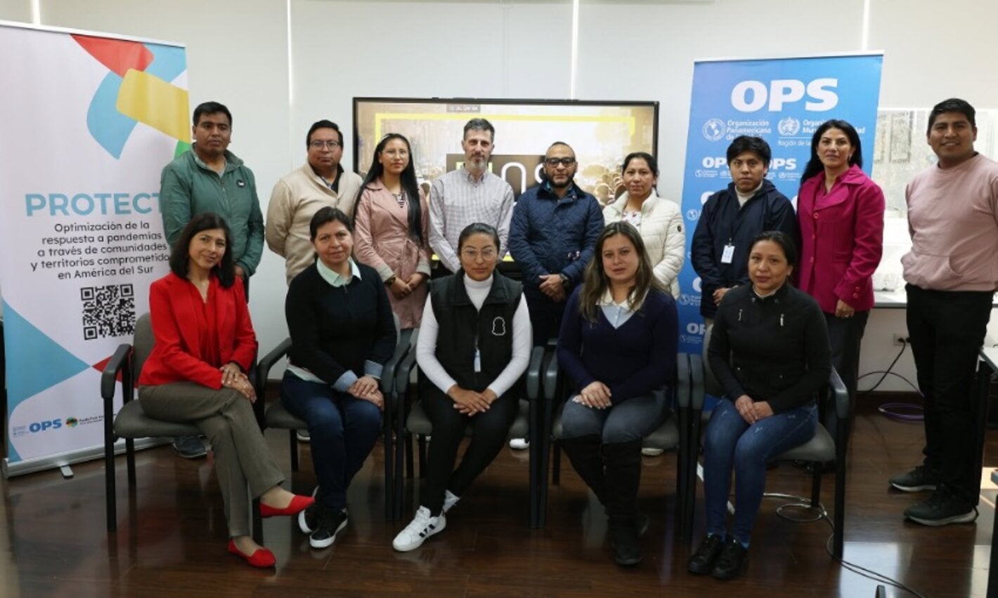 participantes de taller posan para foto junto a banners del evento