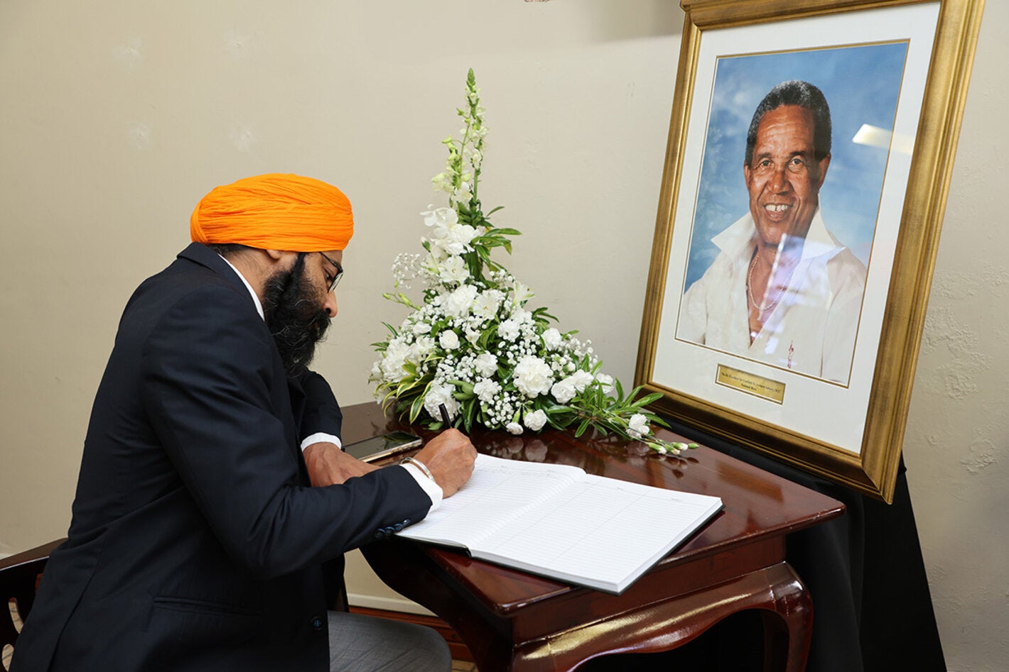 Dr. Prabhjot Singh signs Sir Garfield Sober's condolence book on behalf of PAHO/WHO