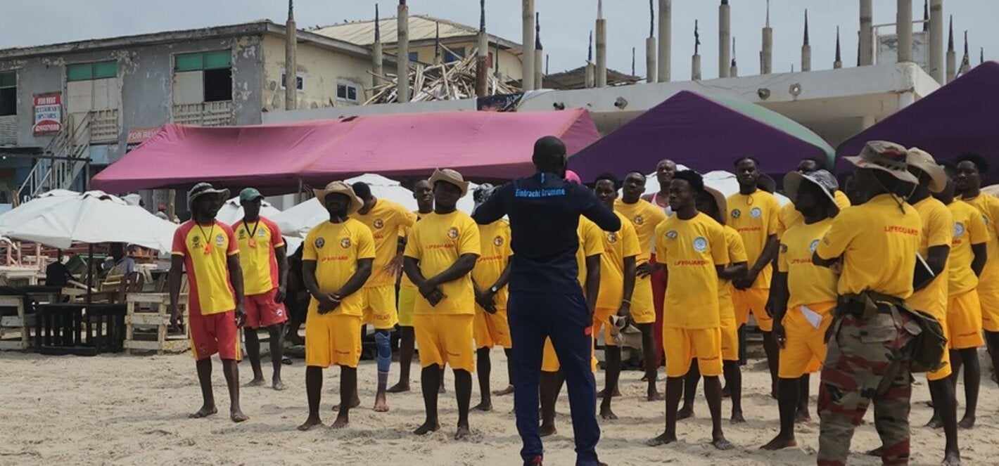 Photo of a group of lifeguards dressed in yellow, in a training session