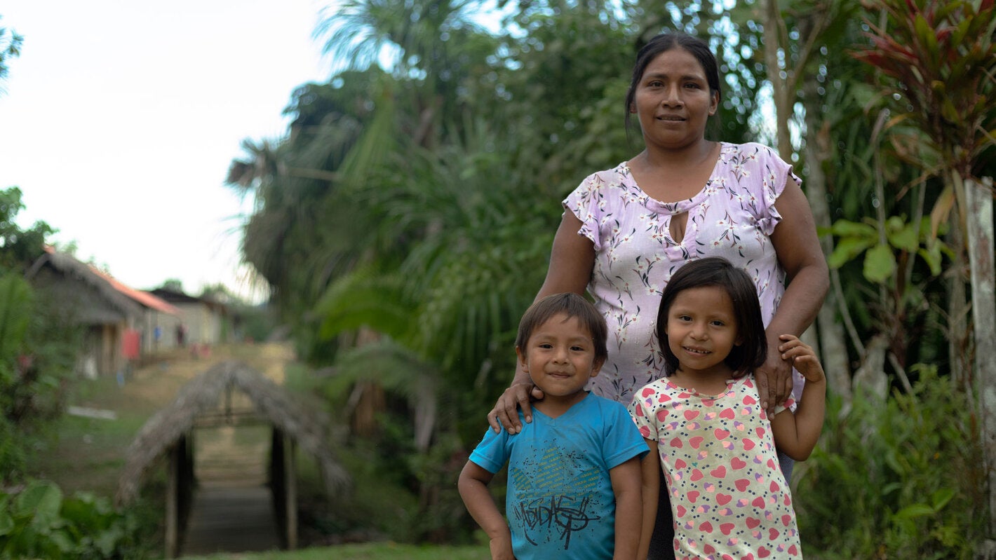 Madre de familia en la Amazonía con su hija e hijo sonriendo