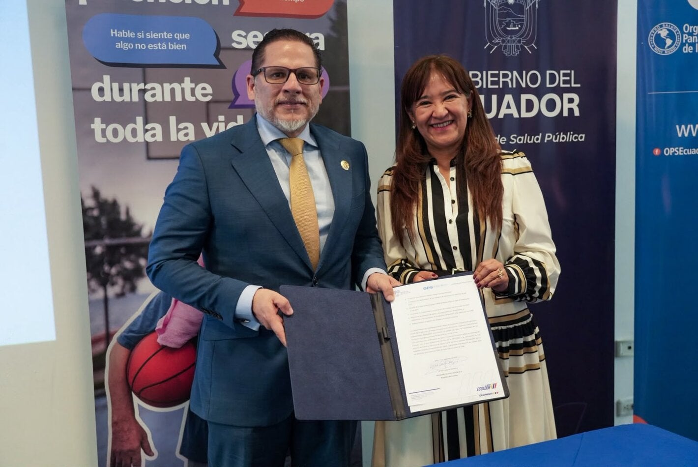 Ministro de Salud Pública, Juan Carlos Aveiga, junto a Sonia Quezada, representante de OPS/OMS Ecuador; muestra documento de Adhesión a la Iniciativa "Mejor Atención a las Enfermedades No Transmisibles".