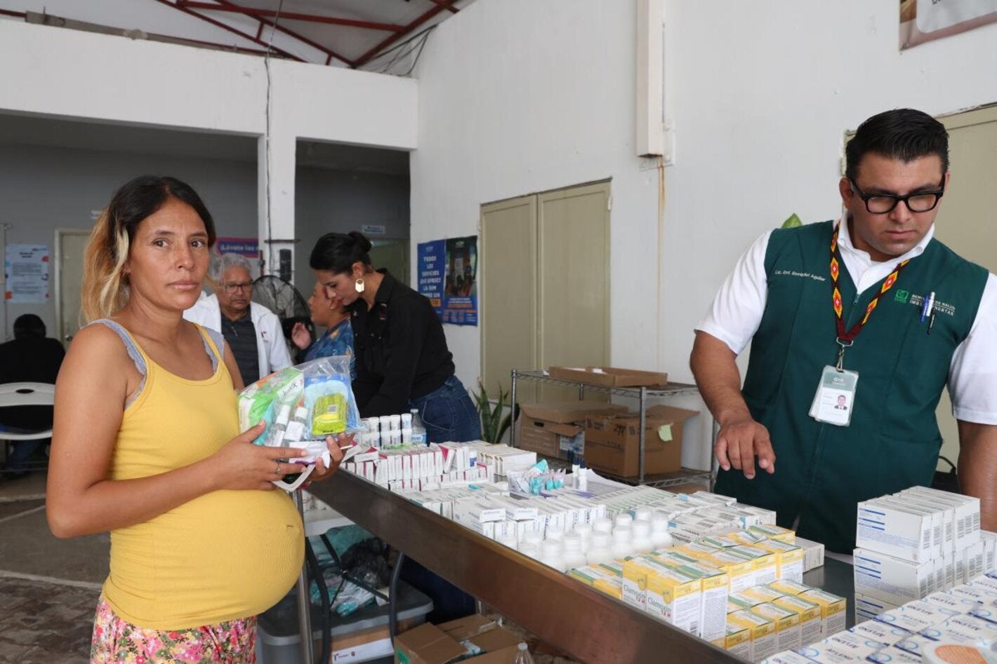 Mujer embarazada recine medicamentos en la Feria de la Salud en Matamoros