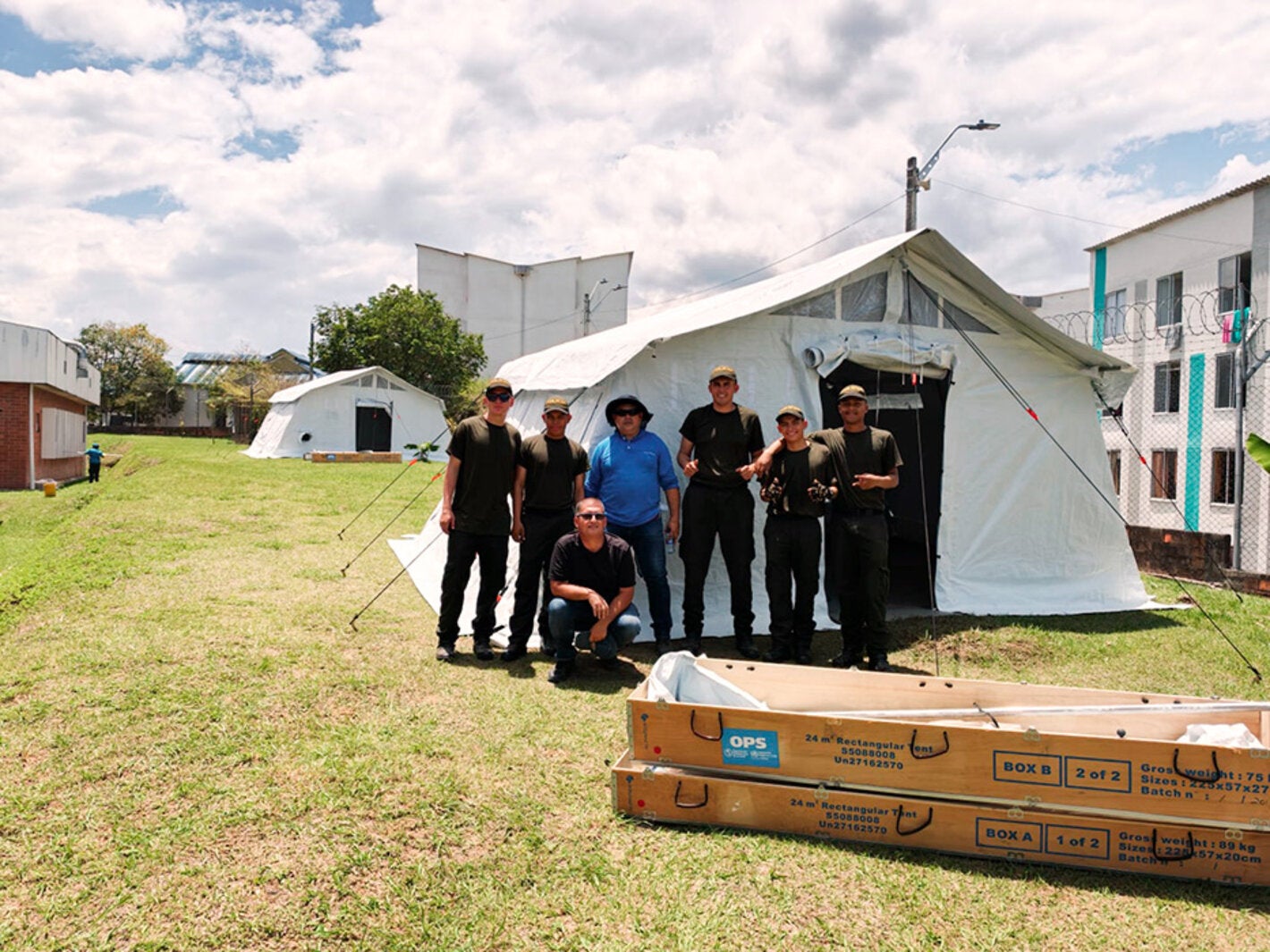 personas posando con una carpa detras