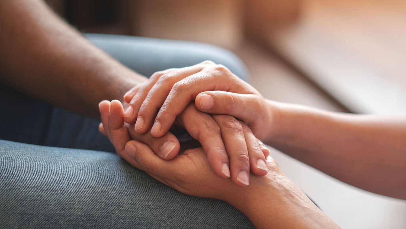  62 Una persona le ofrece apoyo a otra sosteniéndole las manos.