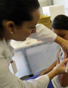 Photo of a nurse applying an injection to a girl´s arm