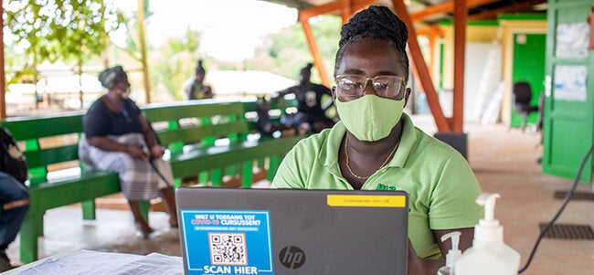 Health worker inputs data onto computer