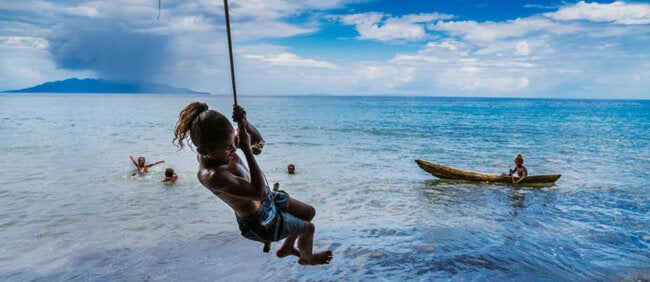 Girl swinging over the ocean