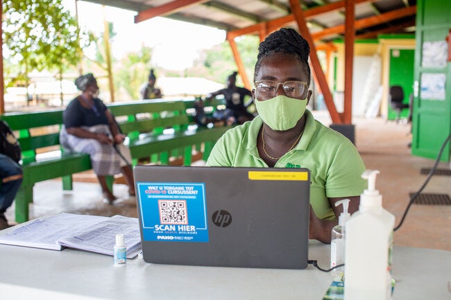 Health worker inputs data onto computer